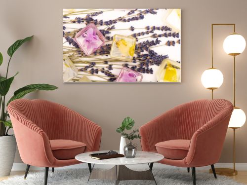 top view of floral and fruit ice cubes and lavender twigs on white surface
