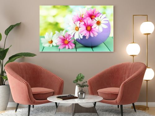 Pot with flowers on a wooden table on the nature background