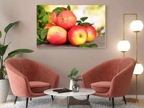Ripe sweet apples with leaves on nature background