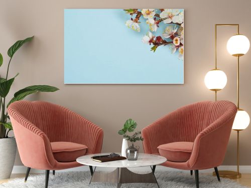 close up of tree branch with blossoming white flowers on blue background