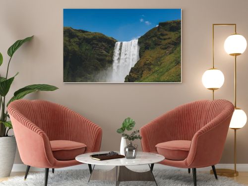 scenic view of waterfall Skogafoss against bright blue sky in Iceland