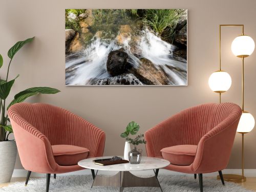 top view of water flowing on rocks near grass in park 