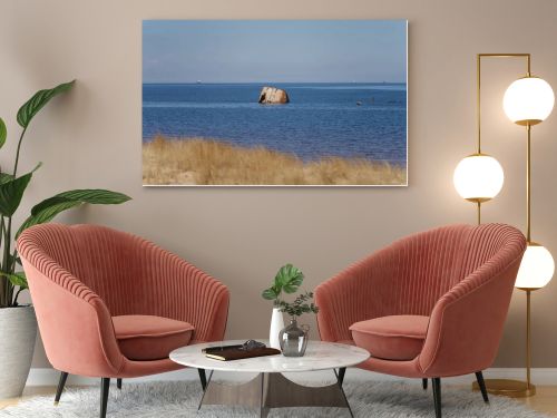 Rusted shipwreck fragment rising from calm sea beyond sandy dune grass, coastal decay, maritime history and Baltic shoreline landscape concept