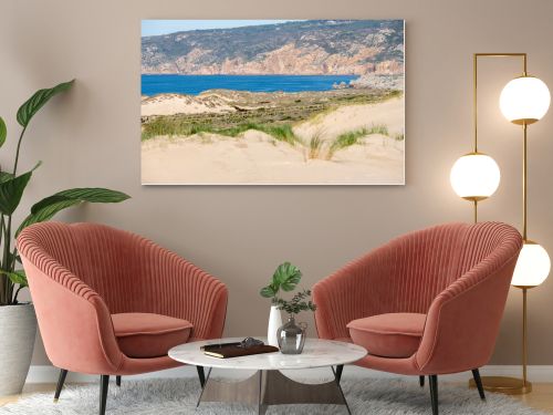 Rolling sand dunes with coastal grass and open Atlantic Ocean views along the Guincho coastline near Cascais Portugal.