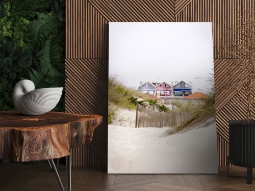 Lovely and quaint beach houses seen from beach dunes. Beach houses with colorful stripes from Costa Nova, Portugal.