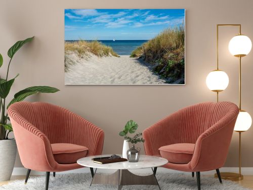 Path between the sand dunes overlooking the sea and a sailing ship and blue sky