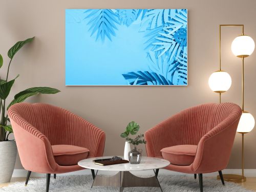 frame of paper leaves on blue minimalistic background with copy space