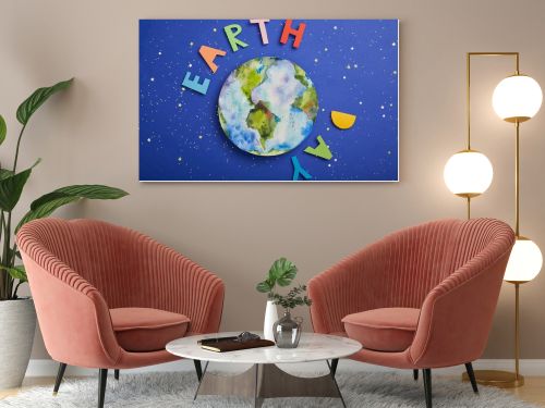 top view of colorful paper letters and planet picture on violet background with stars, earth day concept