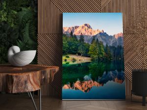 Calm morning view of Fusine lake. Colorful summer sunrise in Julian Alps with Mangart peak on background, Province of Udine, Italy, Europe. Beauty of nature concept background.