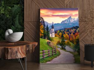 Iconic picture of Bavaria with Maria Gern church with Hochkalter peak on background. Fantastic autumn sunrise in Alps. Superb evening landscape of Germany countryside. Traveling concept background..