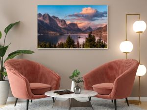 Beautiful Panoramic View of a Glacier Lake with American Rocky Mountain Landscape in the background. Dramatic Colorful Sunrise Sky. Taken in Glacier National Park, Montana, United States.