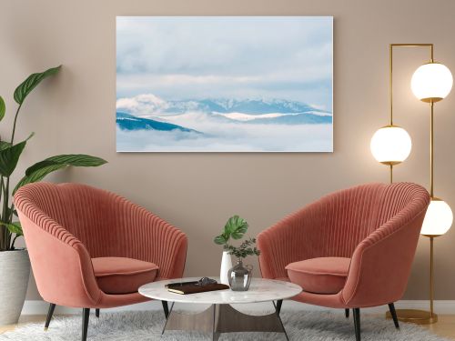 scenic view of snowy mountains in white fluffy clouds
