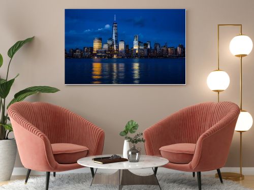 New York City Manhattan downtown skyline with skyscrapers illuminated over Hudson River panorama, including the One World Trade Center