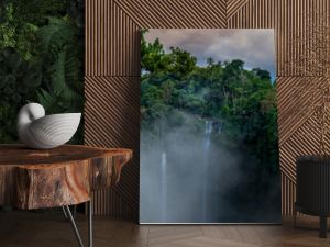 Antena nad wodospadem Sekumpul otoczonym gęstym lasem deszczowym i górami spowitymi mgłą o wschodzie słońca Bali Indonezja panorama