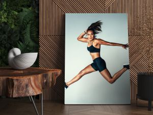 Female model in sports wear jumping in air