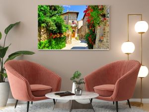 Flower filled medieval street in the beautiful old town of Assisi, Italy