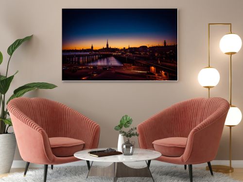 Silhouette of Stockholm cityscape skyline with Riddarholmen Church spires, City Hall Stadshuset tower, bridge over Lake Malaren in Gamla Stan at sunset, dusk, twilight and blue orange sky, Sweden