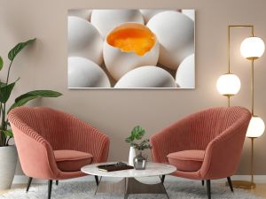 Row of white eggs and single broken egg with a yolk. White Eggs and Yellow Egg Yolk.Shallow depth of field