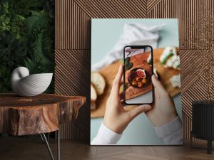 Top view of young woman taking aesthetic photo of food using smartphone in home studio, copy space