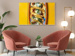 Mexican background with tacos al pastor and mexican sauces. Yellow wooden background, copy space, top view