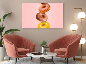 Levitating donuts isolated on a pink background. Modern food concept. Advertising for pastry shops, cafes.