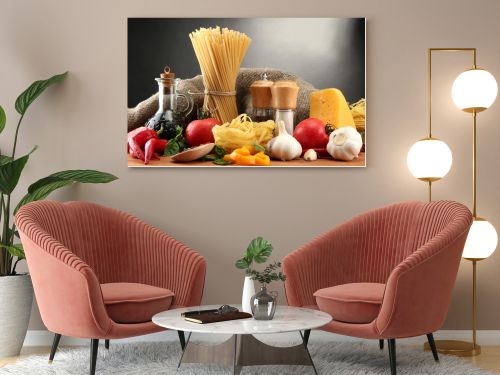 Pasta spaghetti, vegetables and spices, on wooden table, on grey background