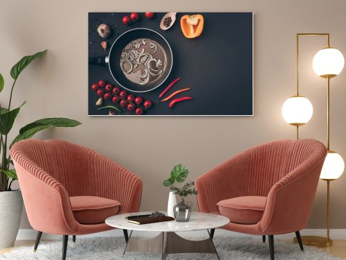 top view of frying pan with onion and oil among vegetables on gray table 