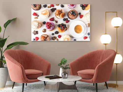 flat lay with cup of coffee, sweet cupcakes, berries, chocolate pieces and hazelnuts isolated on white