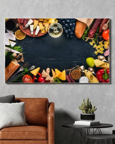 Assorted cheeses, sausages, wines, traditional spices and fresh vegetables on a wooden background. Cheese brie, blue cheese, gorgonzola, fuete, salami. Italian and Spanish Cuisine. Free space.