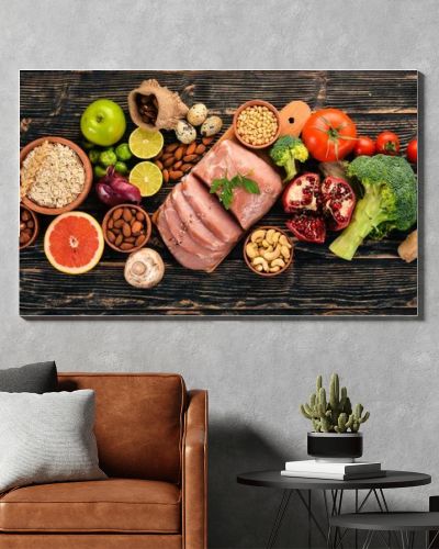 Healthy food. Raw meat, avocado, broccoli, fresh vegetables, nuts and fruits. On a wooden background. Top view. Copy space.