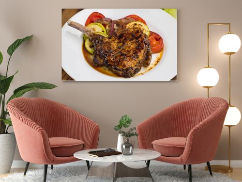 Pork steak on the bone grilled with vegetables. Wooden background. Top view. Close-up