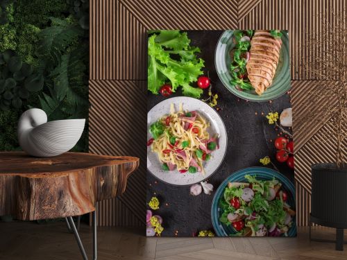 Delicious dinner. Italian pasta, fresh vegetable salad and roasted chicken breast on the black background. Healthy food. Close up. Top view