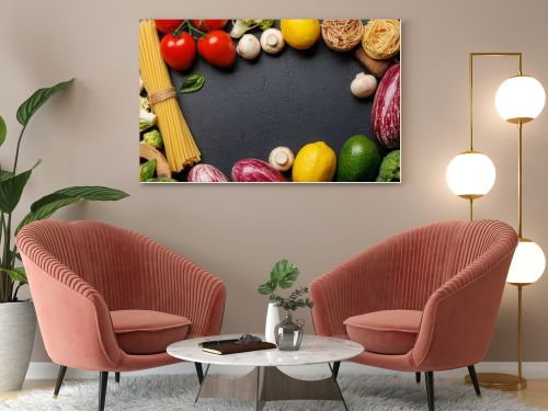 Frame of variety of vegetables and pasta. Flat lay over dark stone background with copy space