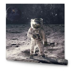 Astronaut on rock surface with space background. Elements of this image furnished by NASA