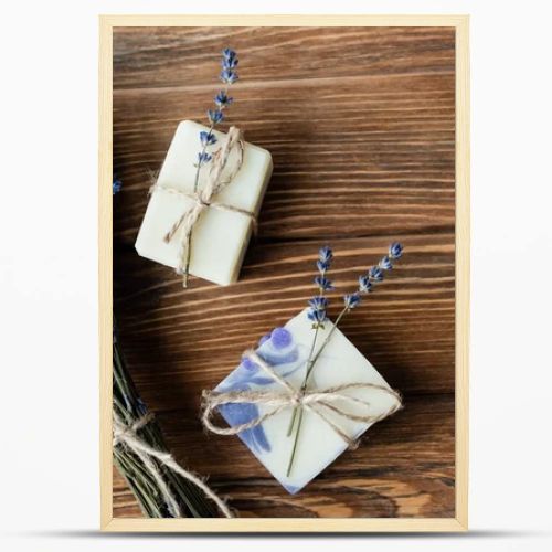 Top view of lavender flowers near handmade soap on wooden surface 