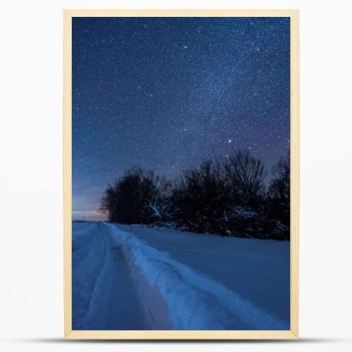 starry dark sky and snowy road in carpathian mountains at night in winter