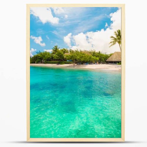 Huahine, French Polynesia. South Pacific. Tropical vacation landscape with lagoon, white sandy beach and palm trees on the island.