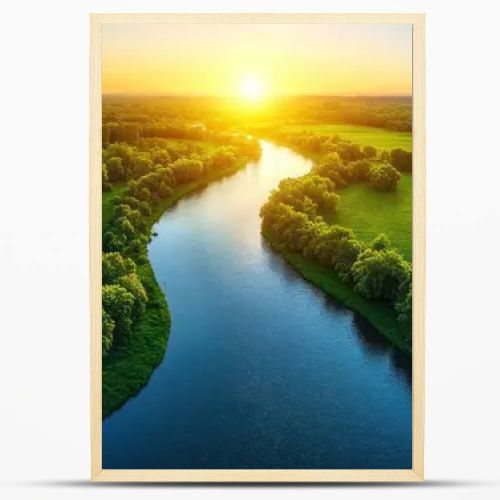 Aerial view of a river flowing through lush green fields at sunset.