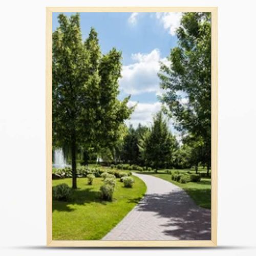 panoramic shot of green trees on grass near fountains