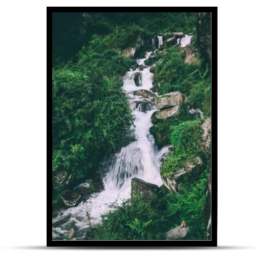amazing waterfall with rocks and green plants in indian himalayas