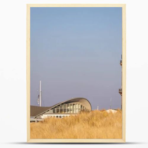 Lighthouse in Warnemuende, Germany with marram grass on sand dunes on the foreground. High quality photo