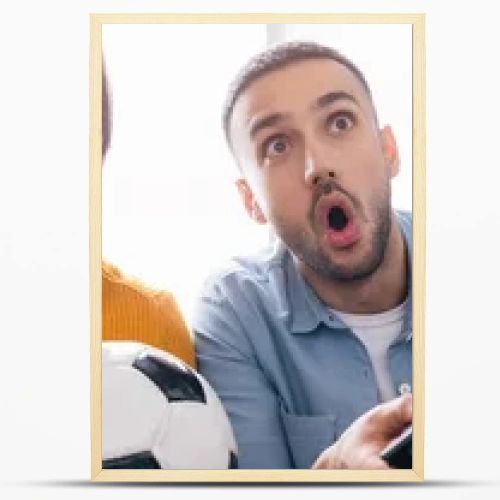 excited interracial father and son watching football championship at home, banner