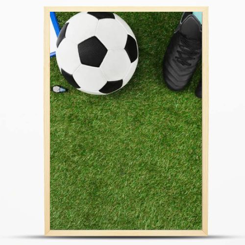 clipboard with soccer ball and boots on grass