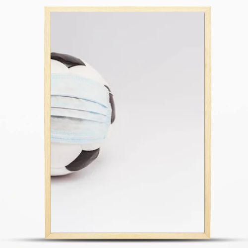 soccer ball in medical mask on white with copy space