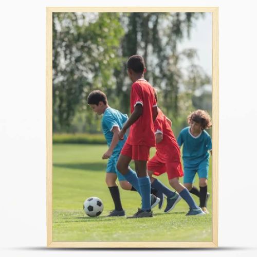 cute kids playing football with african american friend 