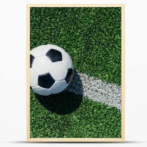 top view of football ball on green grass with white line