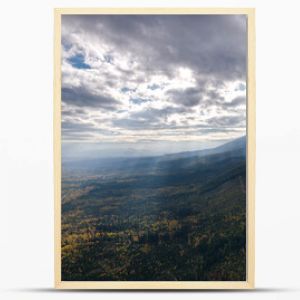 Tatry Słowackie. Niższe tereny zejście z Białej Wody. Widok jak z lotu ptaka. Piękne chmury przez które przebijają się promienie słoneczne. Fotografię dopełniają jesienne kolory drzew. 