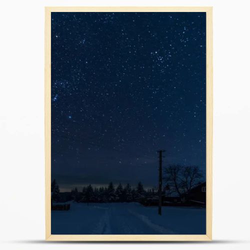 starry night sky above village covered with snow in carpathian mountains