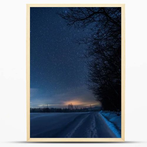 starry dark sky and road in carpathian mountains at night in winter