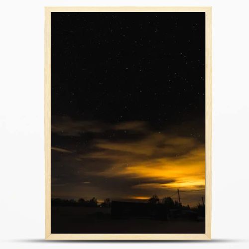 starry dark sky and yellow light in carpathian mountains at night in winter